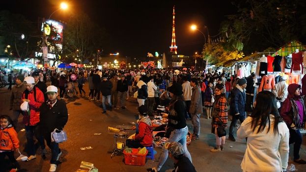 DA LAT, VIET NAM, ASIA- DEC 29: Activity of traveler in outdoor market at night, crowd of people enjoy cold weather in warm clothes, walking on street and shopping, Dalat, VietNam, Asia, Dec 29, 2013