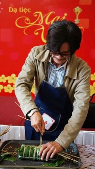 HO CHI MINH CITY, VIET NAM- JAN 15: Actor Cong Ninh make traditional cake in competition, the cake cover by green bananna leaf in Ho Chi Minh, Vietnam on Jan 15, 2013