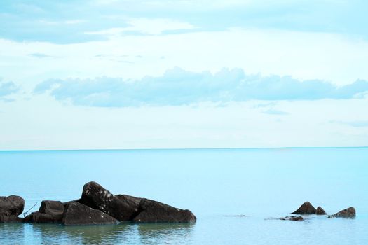 Water's edge on a calm day. Rocks in foreground