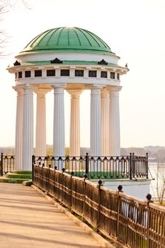 white gazebo with carved pillars on the waterfront