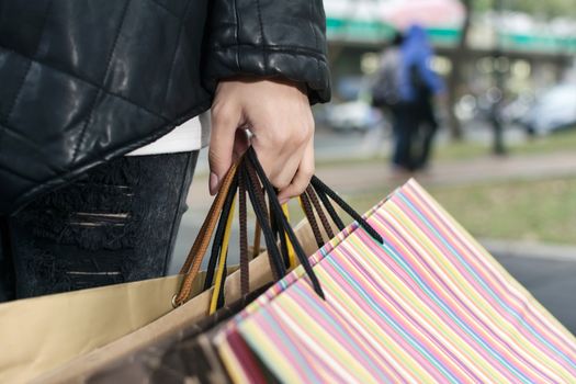 Concept of woman shopping and holding bags, closeup images.