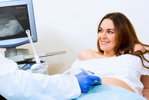 Young attractive pregnant woman on reception at the doctor, health check