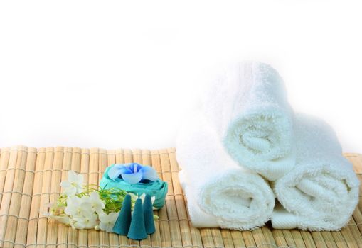 Spa with candles and towel on bamboo mat
