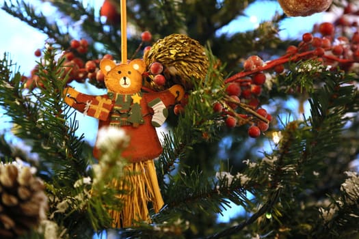 Christmas ornament - flat wooden bear - hanging on the branch of christmas tree