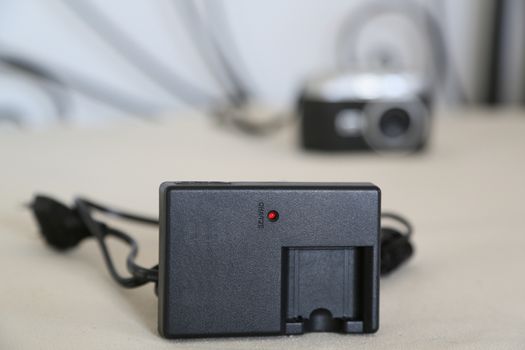 Battery charger for digital camera is placed close to the digital camera itself