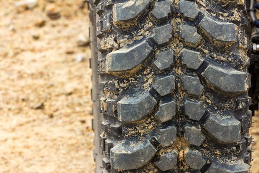 Tread tire coated in mud on an offroad
