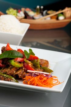 A fresh dish of Thai style roast chile basil duck with mixed vegetables white jasmine sticky rice and thai iced tea.