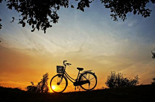 Beautiful landscape of nature with impression of the sun  and silhouette of bicycle  in sunrise at countryside