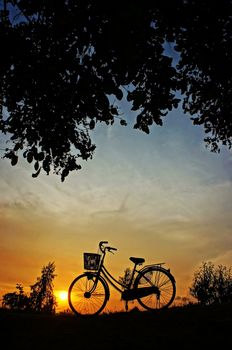 Beautiful landscape of nature with impression of the sun  and silhouette of bicycle  in sunset at countryside