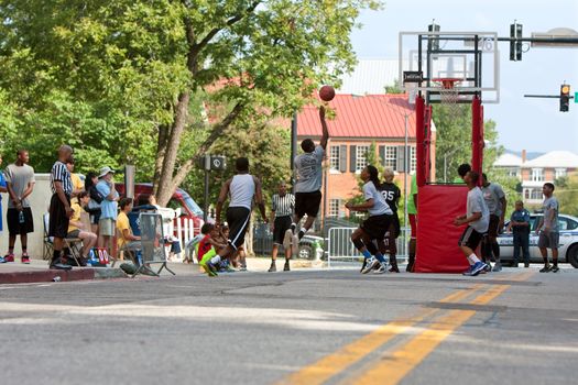 Athens, GA, USA - August 24, 2013:  Several teenage boys compete in a 3-on-3 basketball tournament held on the streets of downtown Athens.