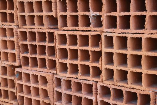 A row of hollow red clay bricks - background