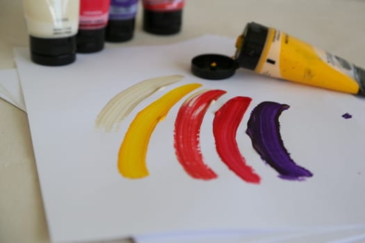 Colorful strokes done by acrylic paints on the white sheet of paper