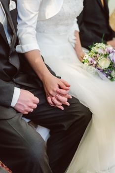 Bridal couple holding hands during wedding ceremony