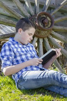 Young boy reading a book in the woods with shallow depth of field and copy space