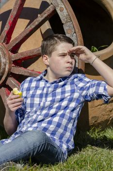 Young boy reading a book in the woods with shallow depth of field and copy space