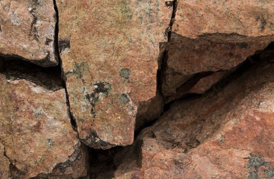 Rock wall background with cracks and holes
