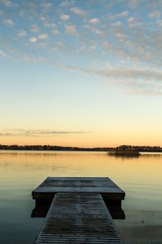 Scandinavian lake in the sunset with frozen  jetty