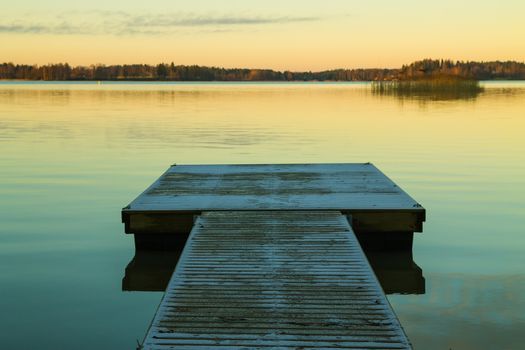 Scandinavian lake in the sunset with a long jetty