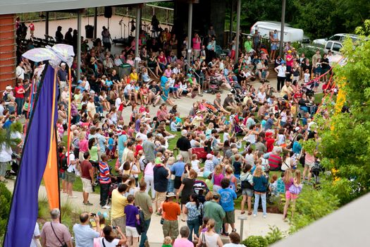 Roswell, GA, USA - July 13, 2013:  A large crowd of people stand and sit on the lawn, waiting for the release of the butterflies at the Chattahoochee Nature Center's summer butterfly festival. Hundreds of people attended the annual event.