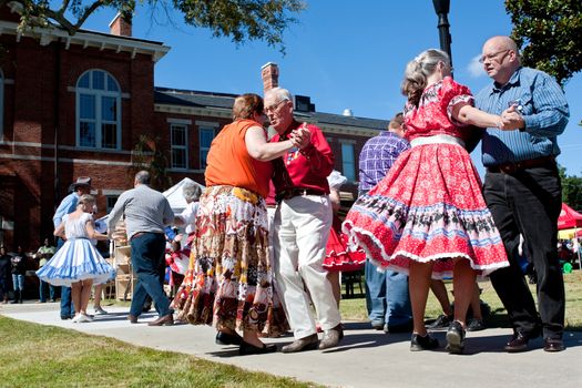 Lawrenceville, GA, USA - October 12, 2013:  Senior citizens square dance outdoors at the Old Fashioned Picnic and Bluegrass Festival.  The event was free to the public.  