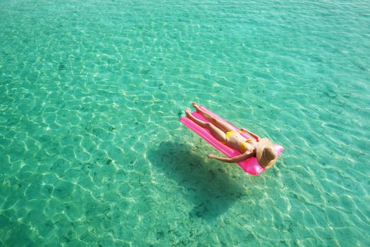 Woman relaxing on inflatable mattress at the beach