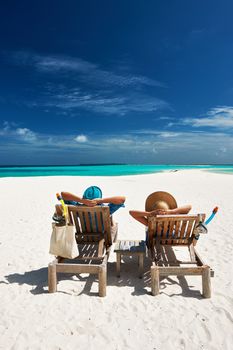 Couple relax on a tropical beach at Maldives