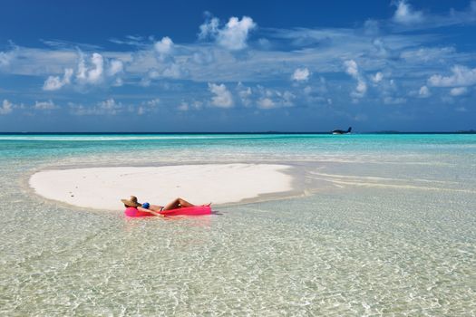 Woman relaxing on inflatable mattress at the beach