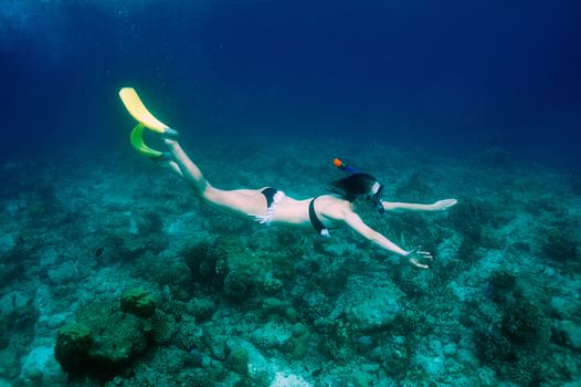 Woman with mask snorkeling in clear water 