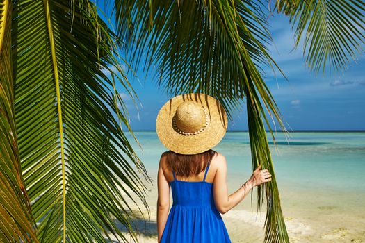 Woman in blue dress on a tropical beach at Maldives