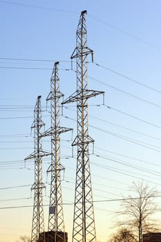 high voltage electric power lines on pylons at sunset