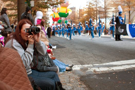 Atlanta, GA, USA - December 1, 2012:  Spectators watch from the street curb as the Atlanta Christmas parade takes place on Peachtree Street in downtown Atlanta. 