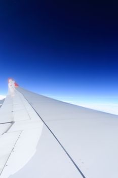 Wing of an airplane flying above the clouds. people looks at the sky