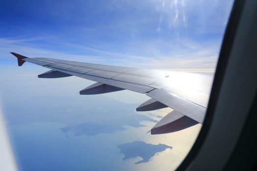 Looking through window aircraft during flight in wing with a nice blue sky