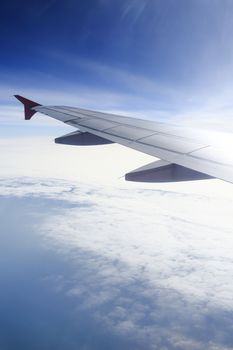 Wing of an airplane flying above the clouds. people looks at the sky