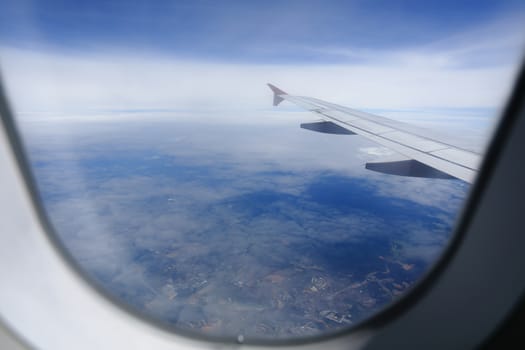 Looking through window aircraft during flight in wing with a nice blue sky