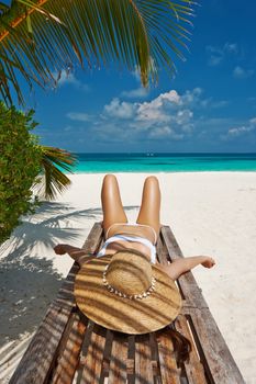 Woman at beautiful beach lying on chaise lounge