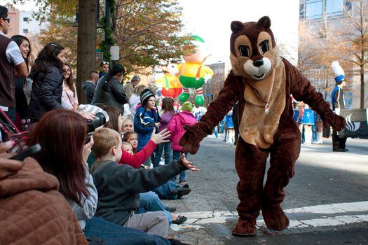 Atlanta, GA, USA - December 1, 2012:  A performer in a chipmunk costume slaps hands with spectators along the route of the annual Atlanta Christmas parade in downtown Atlanta.