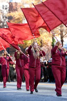 Atlanta, GA, USA - December 1, 2012:   The flag corps of a high school marching band twirls their flags while performing in the annual Atlanta Christmas parade in downtown Atlanta.