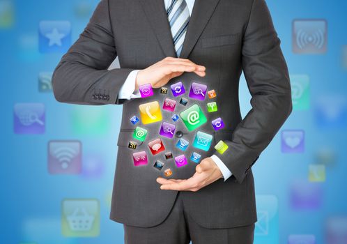 Businessman in a suit holding a app icons. App icons on background
