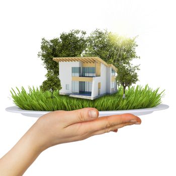 Hand holds a plate. On the plate is a small house, trees and grass