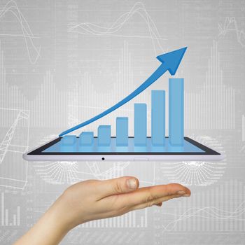 Hand holding a tablet pc. Growth chart on screen tablet