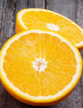 Two Halves of Juicy Ripe Orange closeup on Wooden background