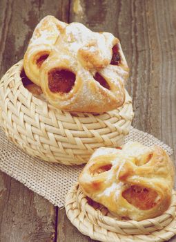 Arrangement of Homemade Pastry Baskets Jam Wrapped with Sugar Powder closeup on Rustic Wooden background. Retro Styled