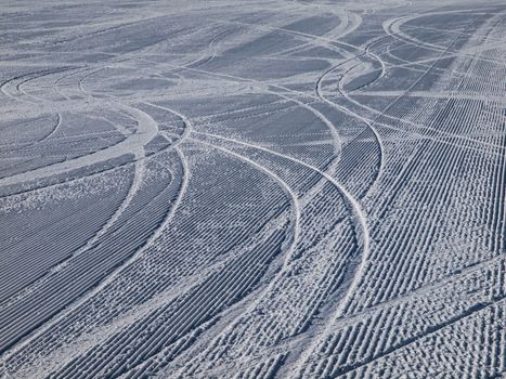 Skiing background - downhill ski tracks on ski slope