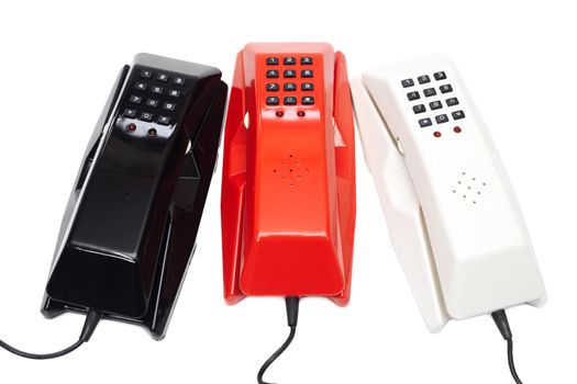 Three old-fashioned plastic wired phones isolated on white