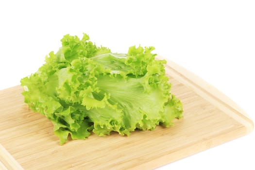 Green salad leaf on cutting board. Isolated on a white background.