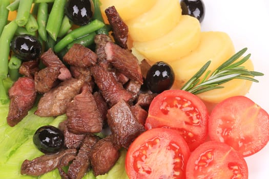 Salad with beef fillet and vegetables. Isolated on a white background.