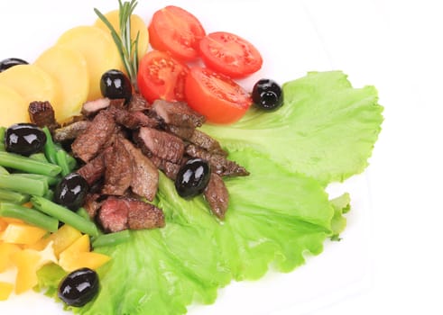 Salad with beef fillet and vegetables. Isolated on a white background.