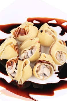 Lumaconi pasta with mushroom sauce. Isolated on a white background.