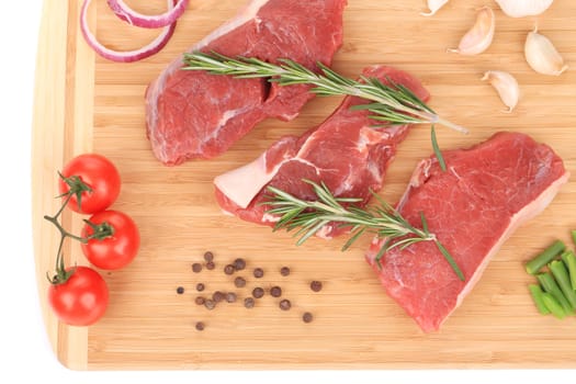 Raw steaks on cutting board. Isolated on a white background.
